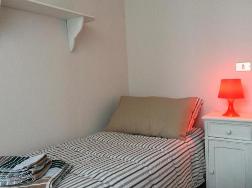 a small bedroom with a bed and a lamp at Le Camere di Casa Cassandra in Perugia
