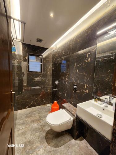 a bathroom with a toilet and a sink at Basil Leaf Resort in Varsoli