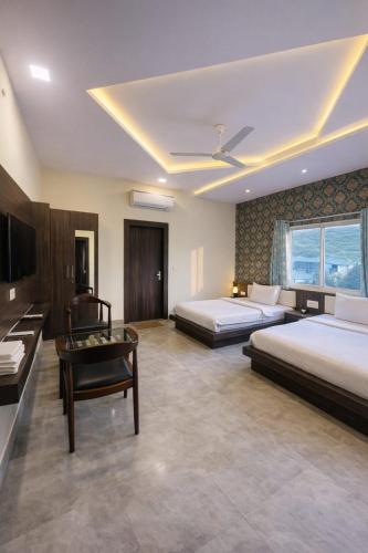 a hotel room with two beds and a desk at Veda Resort in Udaipur
