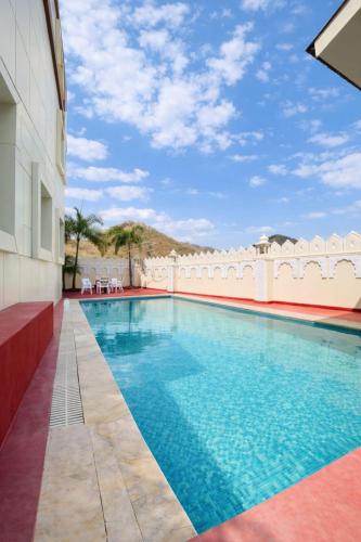 a swimming pool on the side of a building at Veda Resort in Udaipur