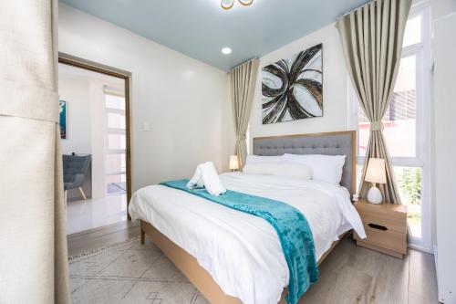 a bedroom with a bed with a blue blanket on it at Haven's Villa in Agus
