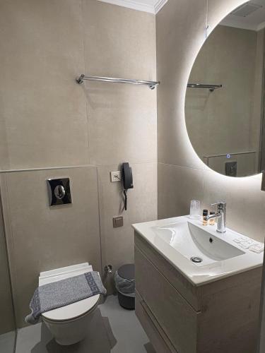 a bathroom with a sink and a toilet and a mirror at Zakros Beach hotel in Tolo