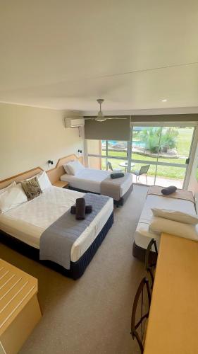 a room with three beds in a room at Atherton Motel in Atherton