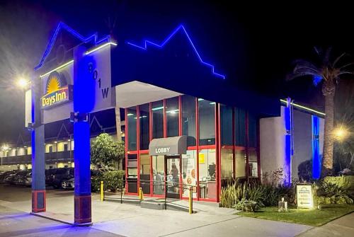 a gas station with a blue arrow sign in front of it at Days Inn by Wyndham Los Angeles LAX Airport Stadium Area in Los Angeles