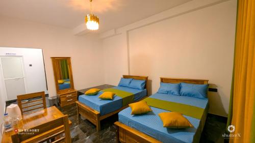 ein Schlafzimmer mit zwei Einzelbetten und einem Spiegel in der Unterkunft MSResort in Haputale
