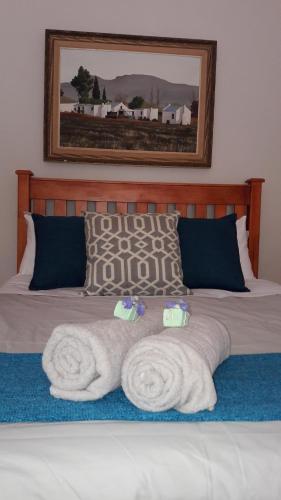 a bed with two towels on top of it at Sanfern Downs Cottage in Haenertsburg