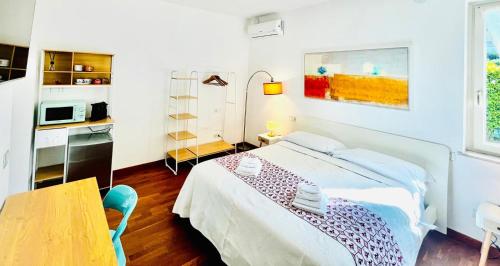 a bedroom with a bed and a table and a microwave at La volpe e l'uva in Lavagno