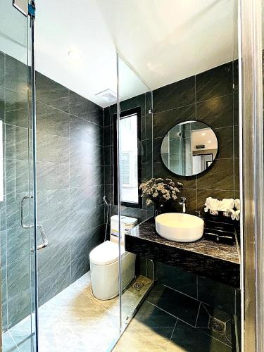 a bathroom with a sink and a toilet and a mirror at Hanora Boutique Hotel in Hanoi