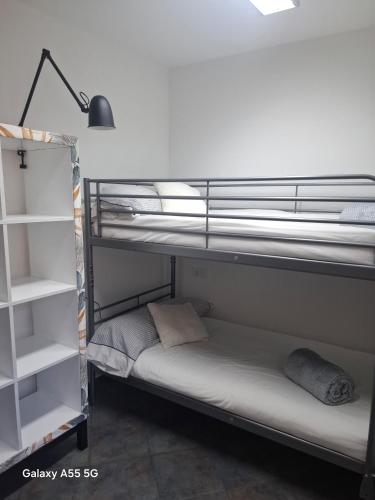 a room with two bunk beds with white shelves at El Fumvial in Arnuero