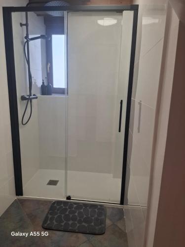 a shower with a glass door in a bathroom at El Fumvial in Arnuero