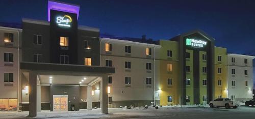 a large building with a sign on top of it at MainStay Suites Great Falls Airport in Great Falls