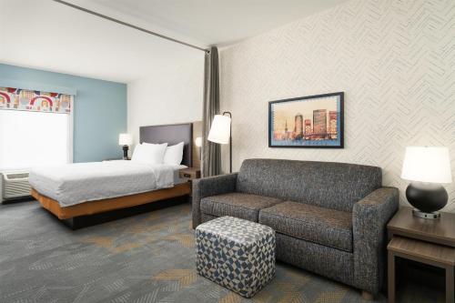 a hotel room with a bed and a couch at Home2 Suites By Hilton Jacksonville Airport in Jacksonville