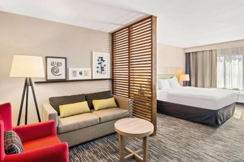 a hotel room with a bed and a couch at Country Inn & Suites by Radisson, Flagstaff Downtown, AZ in Flagstaff