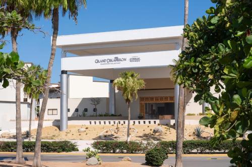 a building with palm trees in front of it at Grand Decameron Los Cabos, A Trademark All-Inclusive Resort in San José del Cabo