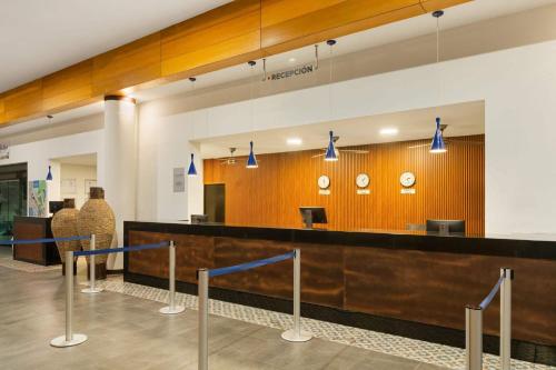 a lobby with a reception desk and a counter at Grand Decameron Los Cabos, A Trademark All-Inclusive Resort in San José del Cabo