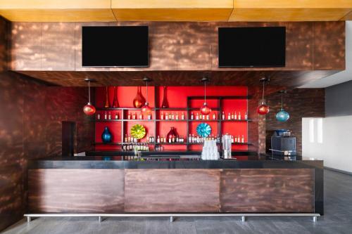 a bar in a restaurant with red walls at Grand Decameron Los Cabos, A Trademark All-Inclusive Resort in San José del Cabo