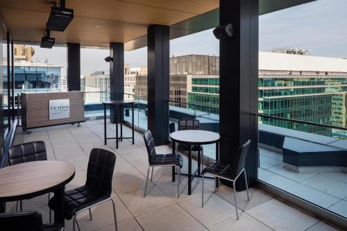 a rooftop patio with tables and chairs on a building at Tempo By Hilton Washington Dc Downtown in Washington, D.C.
