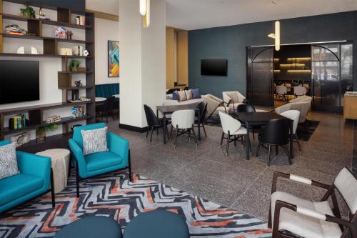 a lobby with a waiting area with chairs and tables at Tempo By Hilton Washington Dc Downtown in Washington, D.C.