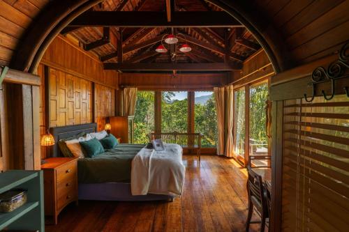 a bedroom with a bed and a large window at Silk Pavilions Glamping in Mount Burrell