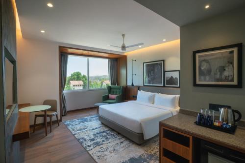 a hotel room with a bed and a living room at Radisson Resort & Spa Sasan Gir in Junagadh
