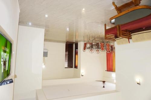 a room with white walls and a chandelier at Sapphire Hotel Apartments in Kakkanad