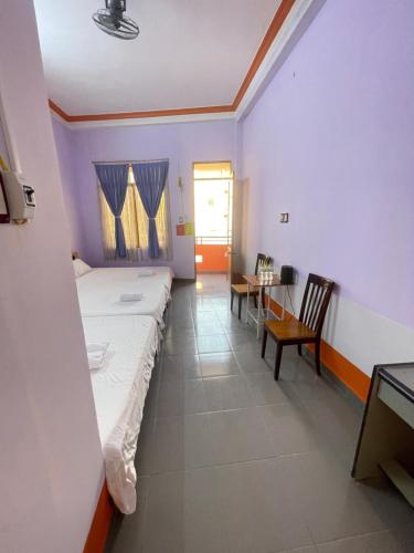 a room with a bed and a table and chairs at Hotel Thúy Hằng Núi Sam Châu Đốc in áº¤p VÄ©nh ÃÃ´ng