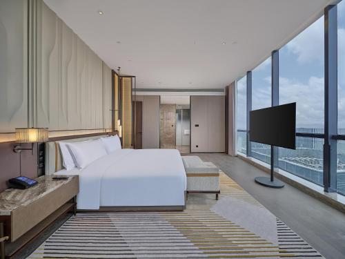 a hotel room with a bed and a tv at Hilton Quzhou in Quzhou