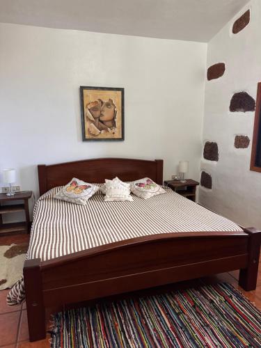 a bedroom with a large bed with a striped mattress at Casa El Sato in Echedo