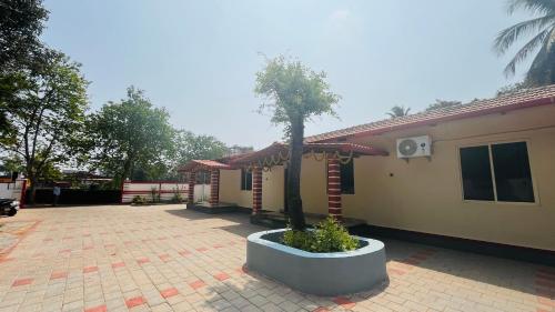 a tree in a pot in front of a house at LX premium cottages - Udupi in Udupi