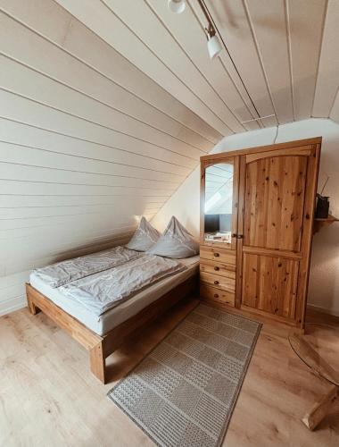 a bedroom with a bed and a wooden cabinet at Appartment, Ferienwohnung auf Fehmarn in Fehmarn