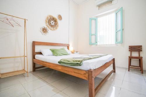 a bedroom with a bed and a window at Homestay Putri Kencono in Yogyakarta