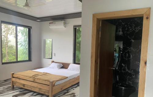 a bedroom with a bed and a window and a door at Lake Side Mantra in Khamshet