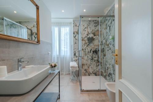 a bathroom with a shower and a tub and a sink at Lolli Palace Hotel in Sanremo
