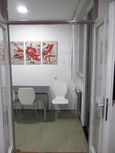 a dining room with a table and white chairs at Door 44 in Zagreb