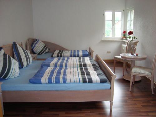 Schlafzimmer mit einem Bett, einem Tisch und einem Fenster in der Unterkunft Zollhaus in Bad Elster