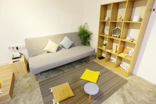 a living room with a couch and yellow chairs at The Gatherings Place in Melaka
