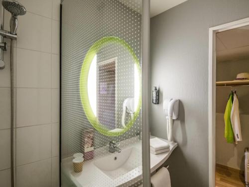 a bathroom with a sink and a mirror at ibis Hyeres Centre in Hyères