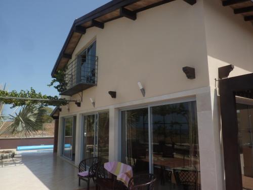 a house with glass doors and a patio at Villa Halcyon Caboverde in Cidade Velha