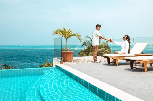 a man and woman shaking hands near a swimming pool at Season Paradise in Thulusdhoo