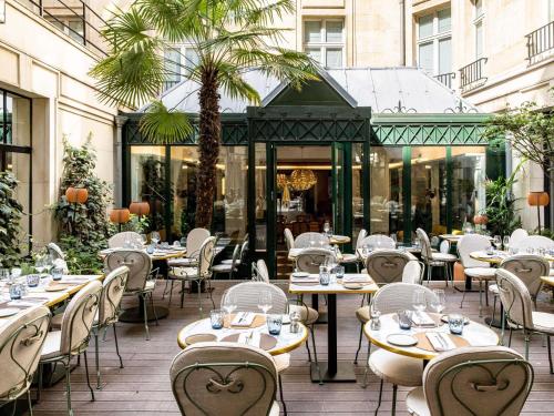 a restaurant with tables and chairs in front of a building at Sofitel Paris Le Faubourg in Paris