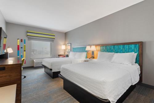a hotel room with two beds and a television at Hampton Inn La Junta in La Junta