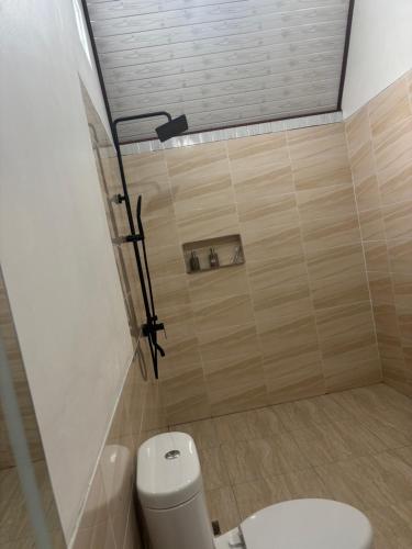 a bathroom with a toilet and a shower at Buana Hill in Kubupenlokan