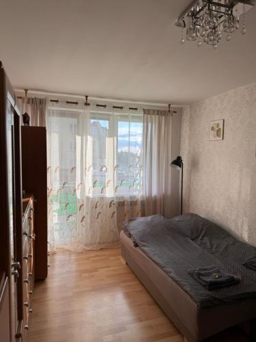 a bedroom with a bed and a large window at Apartament Aria in Ełk