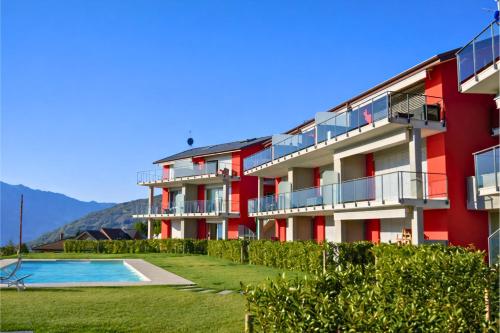 a red building with a swimming pool in front of it at Residenza Roggiolo in Luino