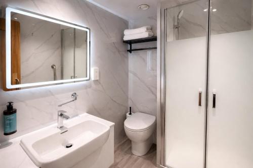 a bathroom with a sink and a toilet and a mirror at Eurotraveller Hotel - Premier - Tower Bridge in London