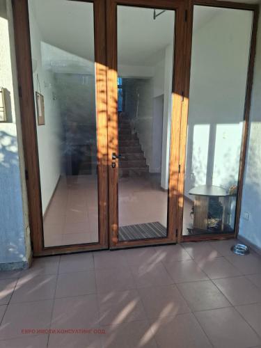 an open glass door of a house with a staircase at Планинска ЗВЕЗДА in Chepelare