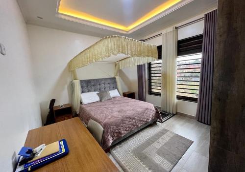 a bedroom with a bed and a table in it at KiGALI NORMAL VIEW APARTMENT in Kigali