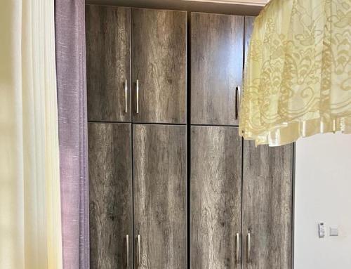 a wooden cabinet in a room with a curtain at KiGALI NORMAL VIEW APARTMENT in Kigali