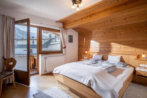 a bedroom with a large bed and a wooden wall at Sophie's Haus in Fügen