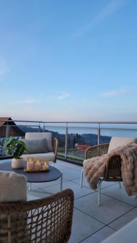 a balcony with a couch and chairs and a table at Ganzes Haus am Bodensee in den Bergen im Appenzell in Heiden